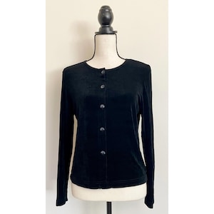 Op de afbeelding: Een zwarte, lange mouw, knoopsluiting cardigan met een ronde hals.