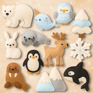 Könnte beinhalten: Eine Sammlung von Filzornamenten mit Tier- und Wintermotiven. Enthält einen Eisbären, ein Narwal, eine Eule, einen Weihnachtsbaum, ein Kaninchen, eine Robbe, ein Rentier, einen Schneeflocke, einen Pinguin, Berge, ein Walross und einen Orca.