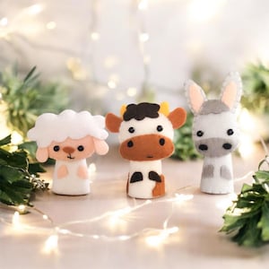 May include: Three felt finger puppets: a white sheep, a brown and white cow, and a grey donkey. The puppets have friendly faces and are perfect for imaginative play.