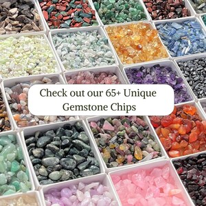 May include: An assortment of 65+ unique gemstone chips in small white boxes. The chips are arranged in rows and columns, showcasing a variety of colors and textures. "Check out our 65+ Unique Gemstone Chips" is written in white text on a white background.
