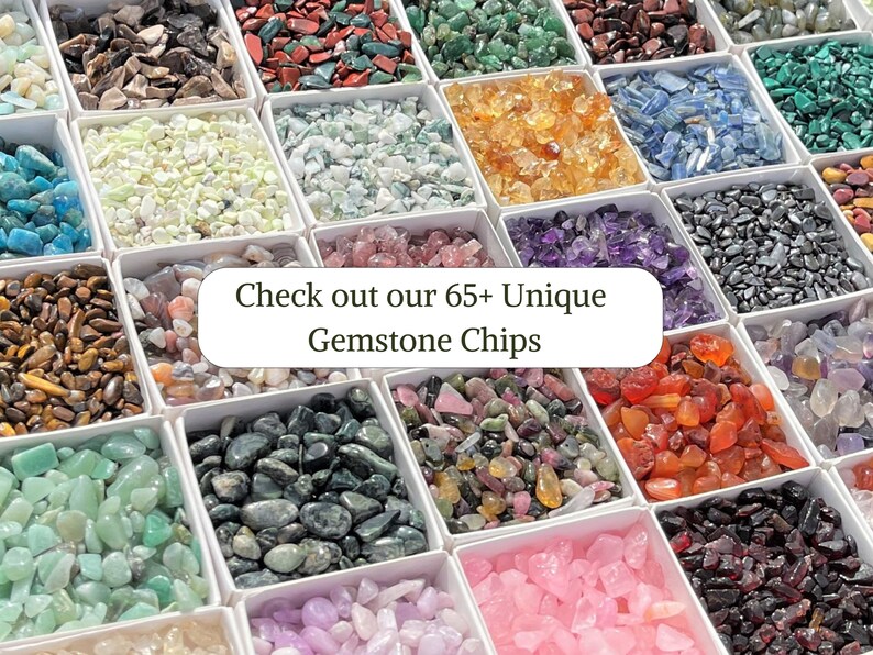 May include: An assortment of 65+ unique gemstone chips in small white boxes. The chips are arranged in rows and columns, showcasing a variety of colors and textures. "Check out our 65+ Unique Gemstone Chips" is written in white text on a white background.
