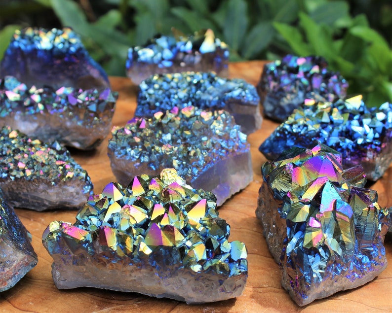 Assortment of Rainbow Aura Amethyst Crystal Clusters on a display board