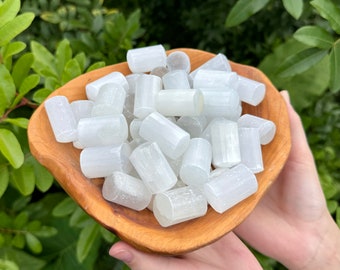 May include: A bowl filled with white selenite sticks. The sticks are smooth and polished, and they have a natural, crystalline texture.