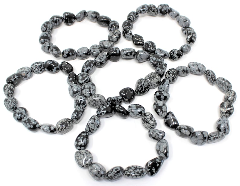 May include: Five black and white snowflake obsidian bracelets. Each bracelet is made of tumbled stones and is approximately 7 inches in length.