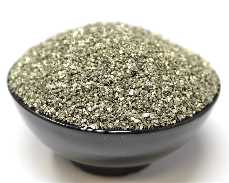 May include: A black bowl filled with a large amount of small, shiny, metallic gold and silver pyrite crystals.