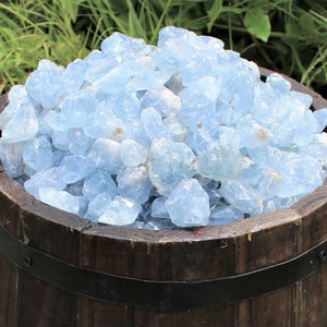 May include: A wooden barrel filled with light blue aquamarine crystals.