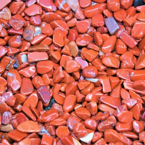 Puede incluir: Primer plano de una colecci&oacute;n de piedras de jaspe rojo. Las piedras son lisas y pulidas, y tienen una variedad de formas y tama&ntilde;os.