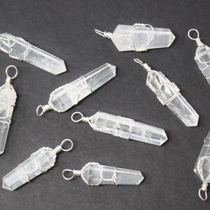 May include: Ten clear quartz crystal pendants wrapped in silver wire. Each pendant has a loop at the top for hanging.