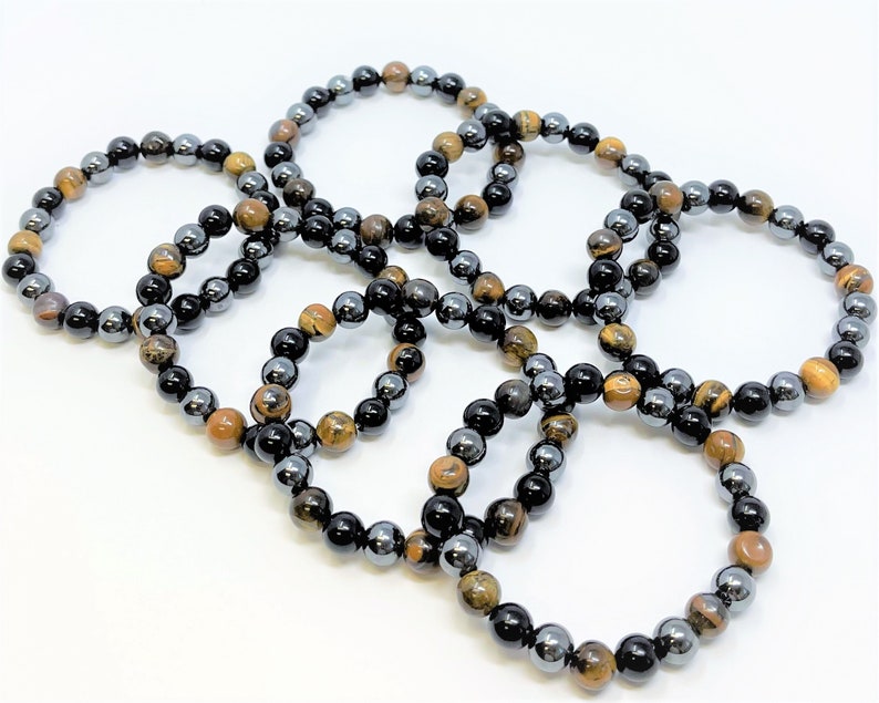 Pode incluir: Seis pulseiras feitas com contas de olho de tigre e hematita. As pulseiras s&atilde;o marrons, douradas, pretas e prateadas.