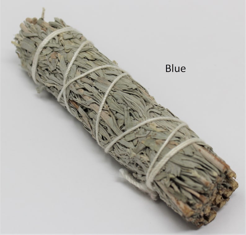 May include: A bundle of dried sage, tied with white string, for smudging. The sage is a light gray color and the text "Blue" is written in black letters on a white background.
