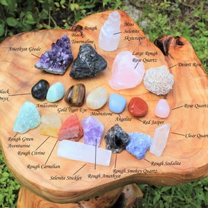 Assorted Crystals lay out and labeled on a wooden decorative table. Amethyst Clusters, Rough Stones, Tumbled Stones and Selenite all mixed together creating a perfectly balanced Beginners Crystal Kit.