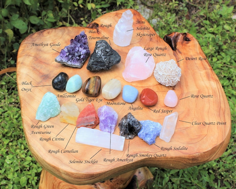 Assorted Crystals lay out and labeled on a wooden decorative table. Amethyst Clusters, Rough Stones, Tumbled Stones and Selenite all mixed together creating a perfectly balanced Beginners Crystal Kit.