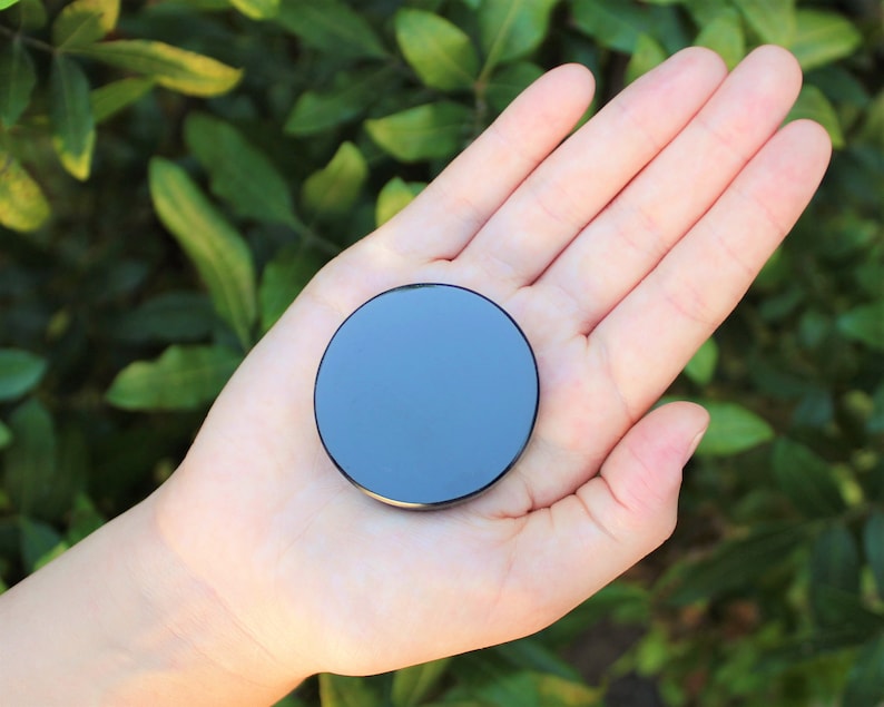 May include: A black round disc with a reflective surface.