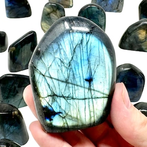 May include: A collection of polished labradorite stones, each with a unique iridescent blue and green color. The stones are smooth and have a natural, tumbled finish.