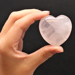 A Large Rose Quartz Heart held between two fingers