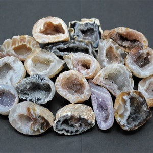 May include: A collection of agate geode crystals with various shades of brown, white, and purple. The crystals have a natural, rough texture and are arranged in a circular pattern.