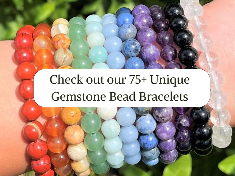 May include: A collection of multi-colored gemstone bead bracelets arranged in a row, featuring red, orange, yellow, green, blue, purple, black, and clear stones. The image includes the text: Check out our 75+ Unique Gemstone Bead Bracelets.