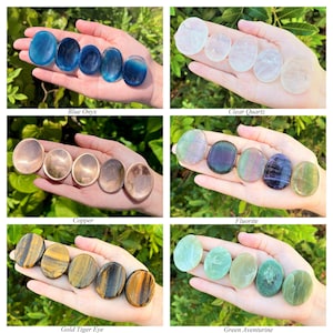 May include: Assortment of polished gemstone palm stones in various colours, including blue onyx, clear quartz, fluorite, gold tiger eye, and green aventurine. Each stone is smooth and oval-shaped, perfect for holding in the hand or using for meditation.