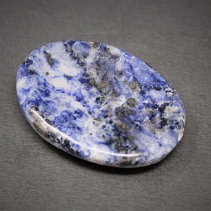 Op de afbeelding: Een ovale, gepolijste steen in blauw en wit met donkergrijze aderen. De steen is glad en heeft een glanzende afwerking.