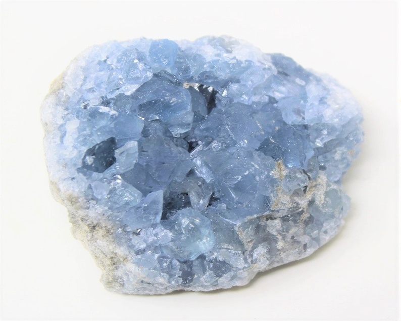 May include: A cluster of light blue celestite crystals with a rough, natural texture.