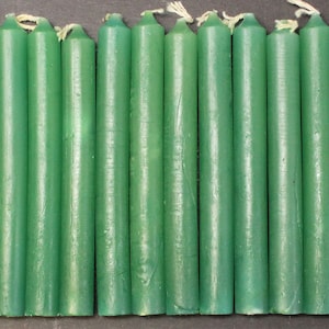 May include: A set of 24 green taper candles. The candles are approximately 6 inches long and are made of a smooth, waxy material.