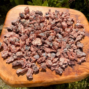 May include: A collection of numerous small, irregular copper nuggets with a metallic, reddish-brown finish. Each piece displays a unique, rough, and textured surface with varying shapes and sizes, showcasing the raw, unrefined appearance of the metal.