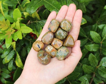 May include: A collection of tumbled green, brown, and white jasper stones. The stones are smooth and polished, with a variety of patterns and colors.