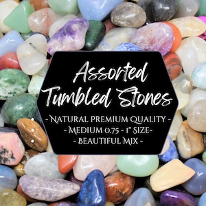 May include: A collection of assorted tumbled stones in various colors, including blue, green, purple, and orange. The stones are approximately 0.75 to 1 inch in size. Text on a black hexagon reads "Assorted Tumbled Stones".