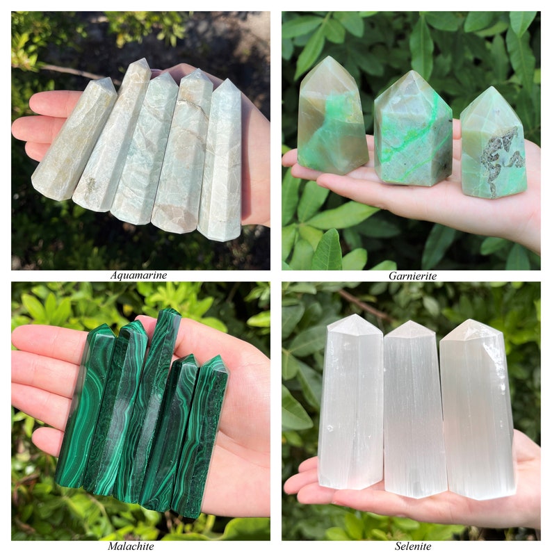 May include: A collection of four crystal towers including pale blue-grey aquamarine, green and brown garnierite, deep green banded malachite, and translucent white selenite, each shaped into a pointed hexagonal column for display.