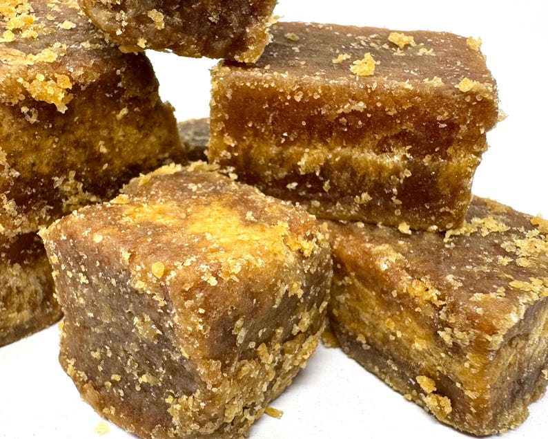 Peut inclure: Gros plan sur des cubes de sucre roux empil&eacute;s. Les cubes pr&eacute;sentent une texture cristalline et une riche couleur brun dor&eacute;. La surface est l&eacute;g&egrave;rement rugueuse, sugg&eacute;rant un produit naturel. L'image met en valeur la texture et la couleur.