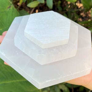 May include: Three white selenite charging plates stacked on top of each other, forming a hexagonal shape.