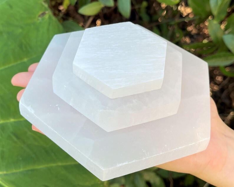 May include: Three white selenite charging plates stacked on top of each other, forming a hexagonal shape.