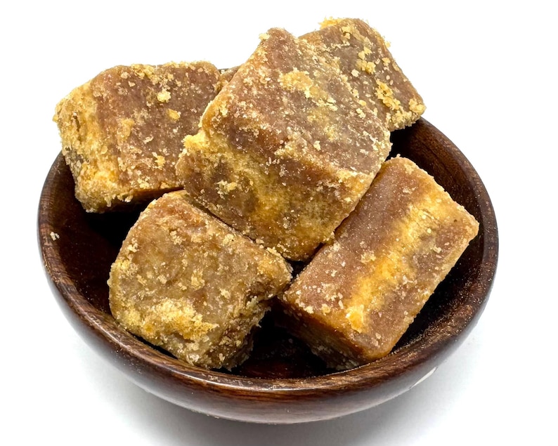 Peut inclure: Un bol en bois rempli de plusieurs blocs bruns, rectangulaires et de forme irr&eacute;guli&egrave;re. Les blocs ont une texture rugueuse et granuleuse et une teinte brun clair, presque dor&eacute;e. Le bol est brun fonc&eacute;.