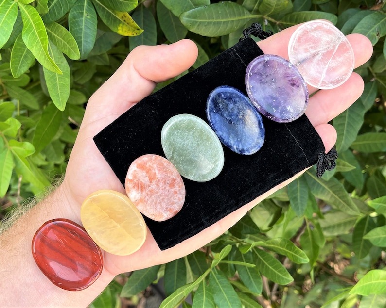 May include: Set of seven chakra stones in a black velvet pouch. The stones are in the order of the chakras: red, orange, yellow, green, blue, indigo, and violet.