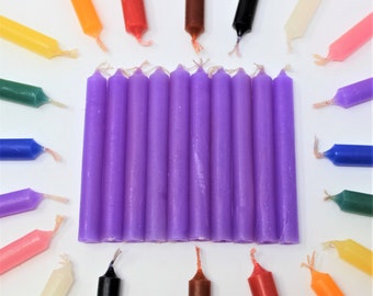 May include: A set of 12 purple candle sticks. The candles are arranged in a row and are all the same size. The candles are a light purple color and have a smooth finish.