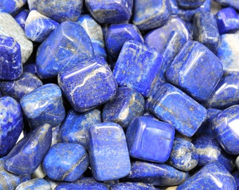 Könnte beinhalten: Nahaufnahme eines Haufens getumbleter Lapislazuli-Steine. Die Steine sind tiefblau mit weißen und goldenen Adern, die durch sie verlaufen.