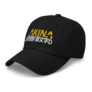 May include: Black baseball cap with a yellow embroidered logo that says "AKINA SPEED STARS 漢字D".