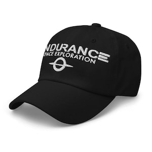 May include: Black baseball cap with white embroidered text that reads "Endurance Space Exploration" and a stylized white ring.