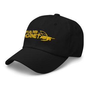 May include: A black baseball cap with a yellow embroidered logo that says "F/A 18 Hornet" and a stylized hornet graphic.