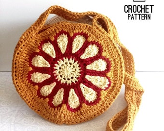 Può includere: Schema a uncinetto per una borsa a tracolla rotonda di colore senape con un motivo floreale rosso e crema. Lo schema è disponibile per il download in PDF.