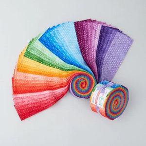 May include: A collection of colorful fabric strips arranged in a rainbow gradient, with a polka dot pattern. The fabric is rolled into a spiral and tied with a ribbon. The fabric is suitable for quilting and crafting projects.