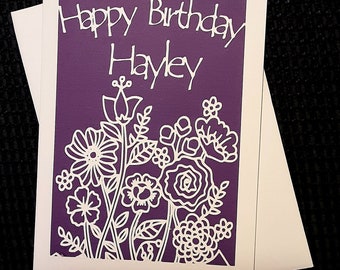 Tarjeta de cumpleaños recortada en papel con un jardín de flores