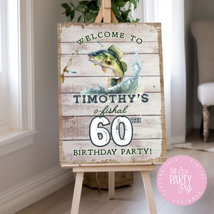 Op de afbeelding: Welkom op Timothy's o-fishal 60e verjaardagsparty! Een rustiek bord in houtlook met een groene en bruine vis die uit het water springt. Het bord staat op een ezel.