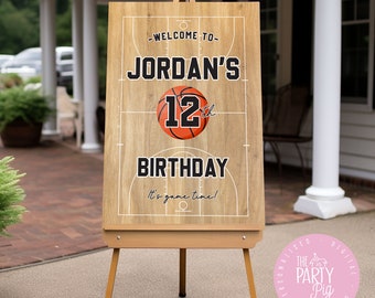 Peut inclure: Une pancarte d'accueil en bois avec un design de terrain de basket-ball. La pancarte indique "Bienvenue à Jordan's 12ème anniversaire. C'est l'heure du jeu !"