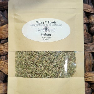 May include: A brown paper bag with a clear window showing dried herbs inside. The bag has a label that reads "Jazzy T Foods" and "Italian Herb Blend 0.5 oz."