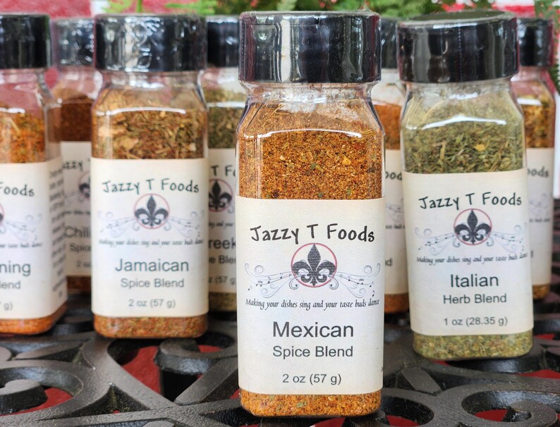 May include: Several glass spice jars with black lids, each labelled with a different spice blend name. The labels feature the "Jazzy T Foods" logo and include the spice blend name and weight in ounces and grams.