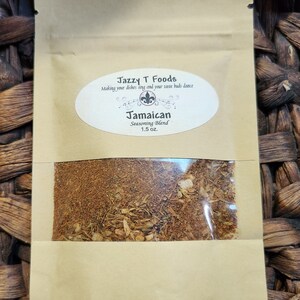 May include: A brown paper pouch with a clear window showing a brown spice blend. The pouch has a label that reads "Jazzy T Foods" and "Jamaican Seasoning Blend 1.5 oz."