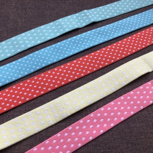 May include: Five different polka dot patterned elastic bands in various colours, including light blue, blue, red, yellow and pink.