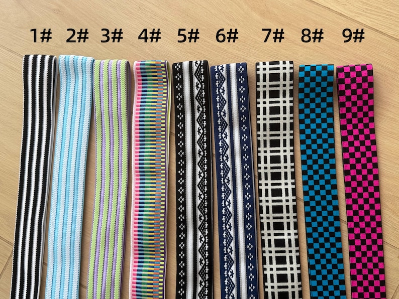 Op de afbeelding: Negen verschillende elastische banden met verschillende patronen en kleuren worden getoond. De banden omvatten zwart-witte strepen, lichtblauwe strepen, groen-paarse strepen, een regenboogpatroon, zwart-witte geometrische ontwerpen, marineblauwe en witte patronen, zwart-witte ruitjes, blauwe ruitjes en roze ruitjes.