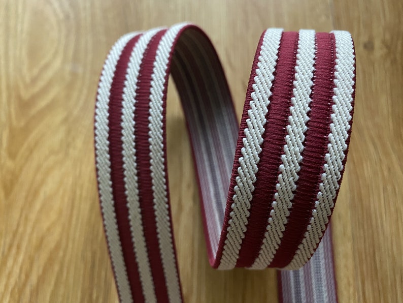 May include: Red and white striped elastic webbing with a textured surface.